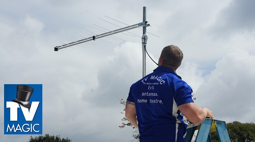 technician installing a new antenna system on the roof of a home