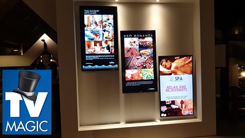 a multi-TV display in a retail setting with a TV Magic logo in top left corner