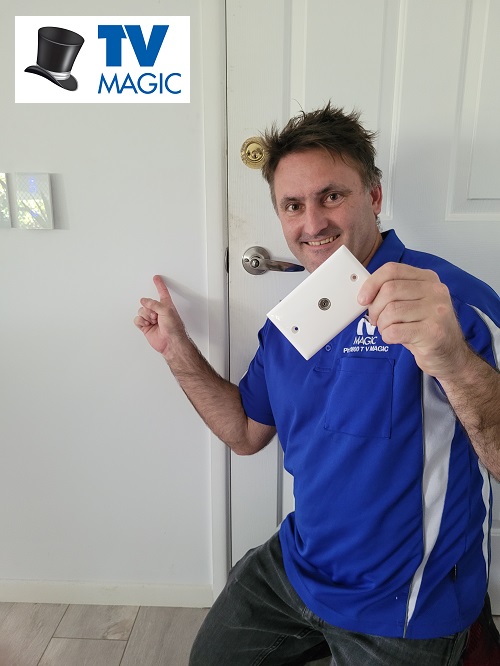 technician holding a TV point and pointing to a wall 