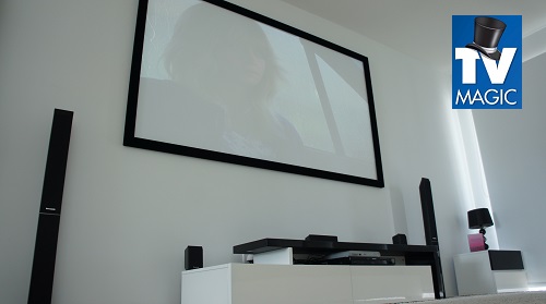 full home theatre setup with projector screen and surround sound. TV Magic Logo in top right corner