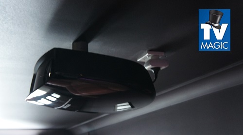 a black ceiling mounted projector with a TV Magic logo in top right hand corner