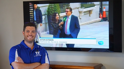a technician in front of a wall mounted TV where a new TV point was installed