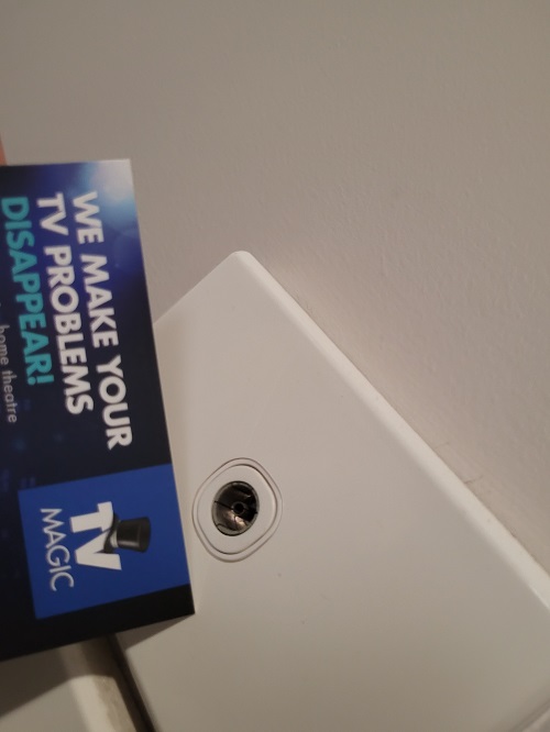 a TV point installed on a plaster wall, with a TV Magic card overlapping it on left hand side