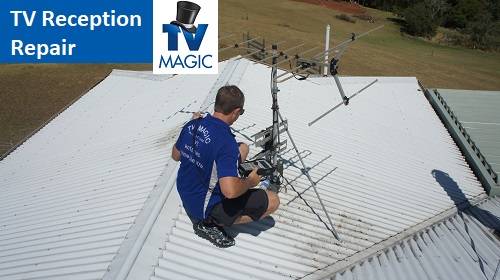technician on a roof repairing an antenna. In top left corner there is a caption "TV reception repair" with a TV Magic logo overlapping