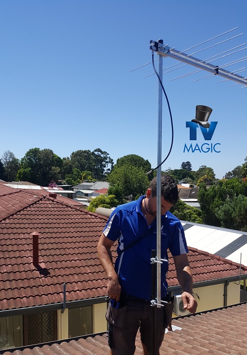 Technician installing a new antenna. Logo below antenna