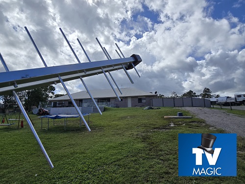 An antenna held out, with property in the background.