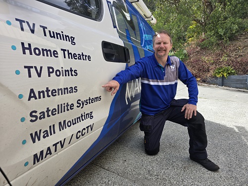Technician pointing to antenna services on side of van