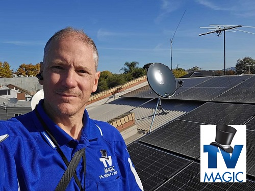 Technician showing off an antenna and satellite dish relocation he performed