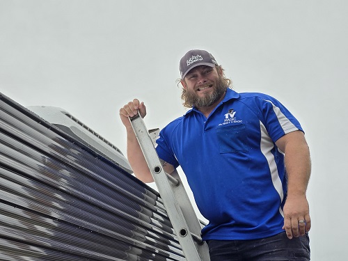 Technician on a ladder, on side of caravan