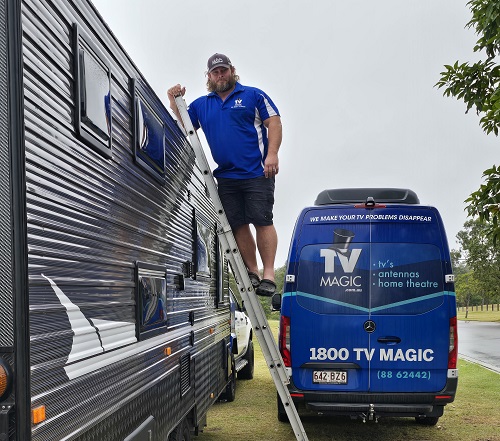 a photo of technician - Nick on ladder on side of caravan