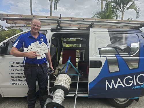 Technician holding TV points next to rolls of cabling.
