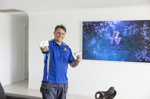 Technician standing in front of a TV, holding a TV point