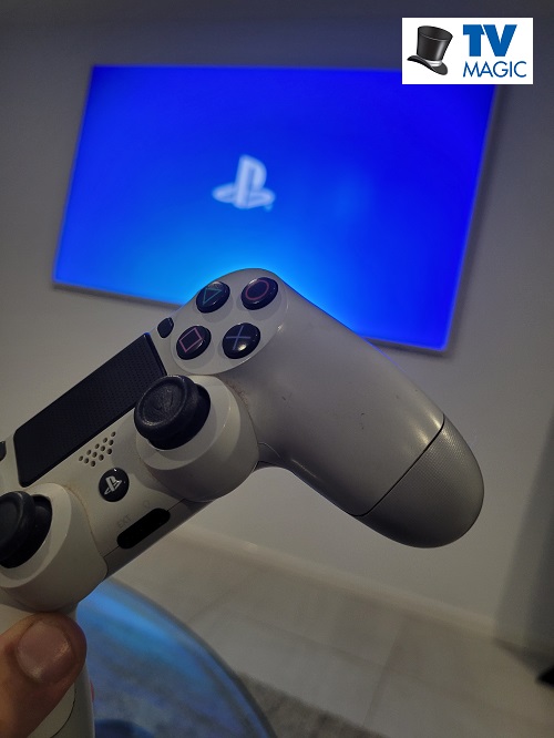 A PlayStation remote in front of TV