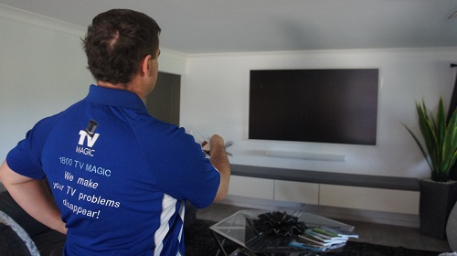 Technician setting up a home theatre in a client living area