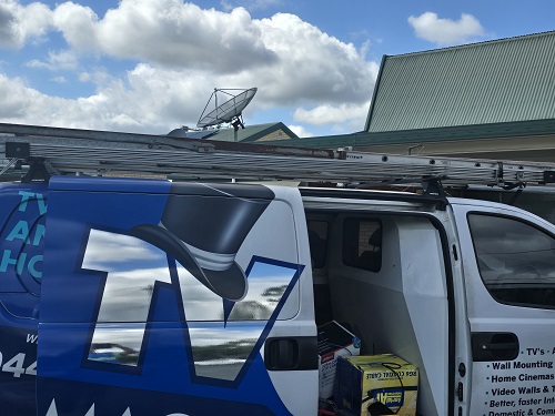 TV Magic van with satellite dish on a roof in the distance.