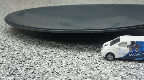 close up of a satellite dish with mini TV Magic van in front of it