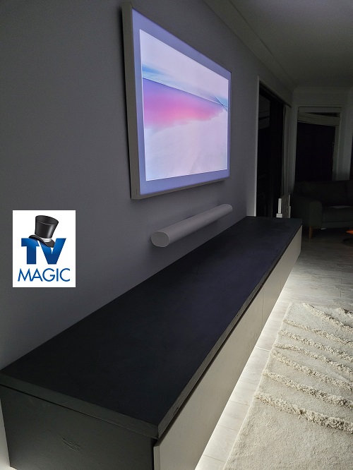 Side view of a TV Magic wall mounted TV with soundbar