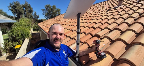 Technician with a Starlink internet installation he just completed