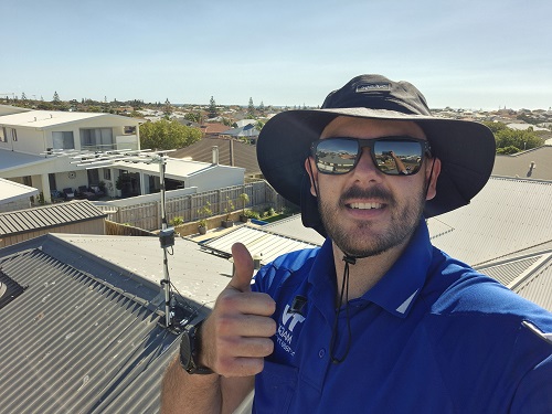 Technician on a roof with an antenna he installed