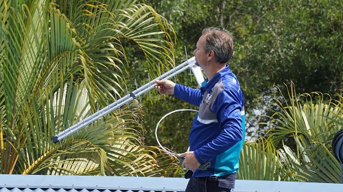 Technician holding an antenna and cable, ready to install