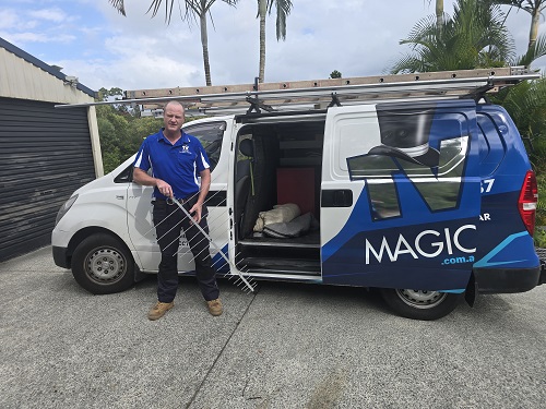 technician holding an antenna - standing next to his van 