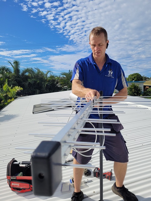 Technician mending a TV reception issue