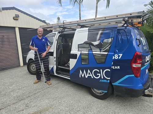 Technician with an antenna, standing beside his van.
