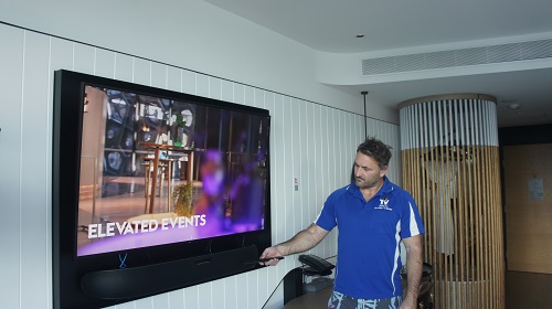 Technician setting up a new TV he installed