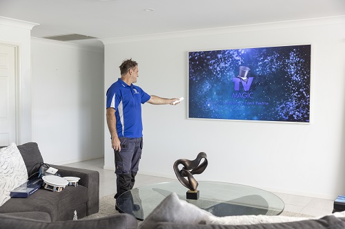Technician tuning in a new TV post installation