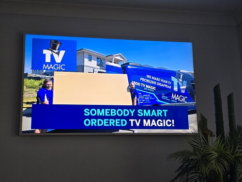 Technicians moving a large TV - Somebody smart ordered TV Magic!