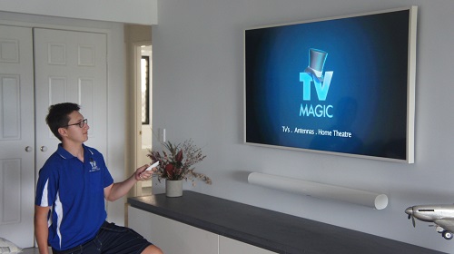 Technician holding a remote after tuning a customers TV