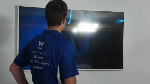 Technician facing wall mounted TV