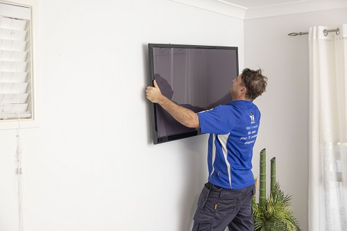 Technician mounting a TV on the wall
