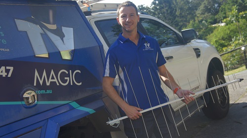 Technician holding an aerial next to his van