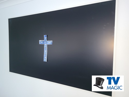 Wall mounted TV with cross on screen. Logo in bottom right corner