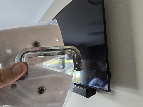 New TV point held up in front of a wall mounted TV
