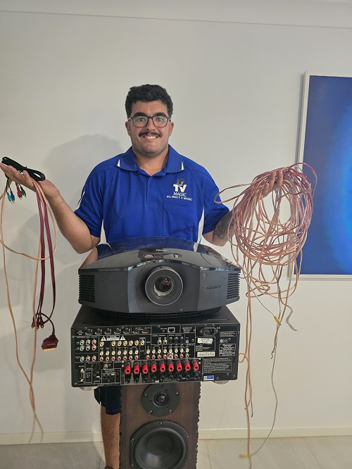 Technician with projector, speaker, and lots of cabling