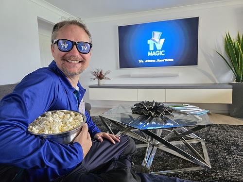 Technician with popcorn in front of a large screen