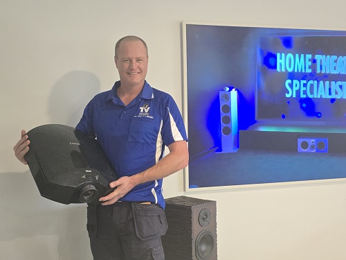Technician holding a projector in a South Bunbury home.