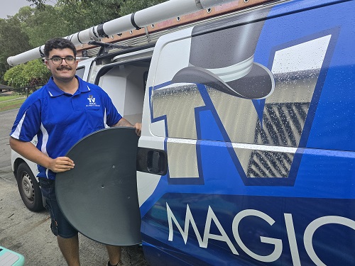 Technician with a satellite dish from his van