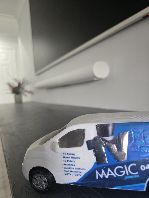 Close up of a mini TV Magic van under a floating soundbar