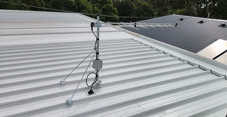 Close up of an antenna on a tin roof.
