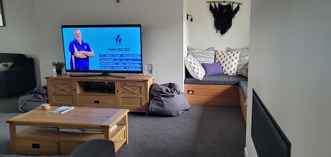 Living room with a TV Anton installed. Anton and his services on screen.