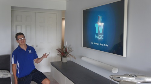 Technician with TV remote in client living room