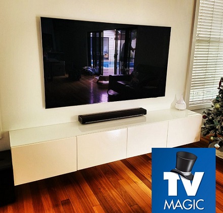 wall mounted TV and sound bar with TV Magic logo in bottom right corner