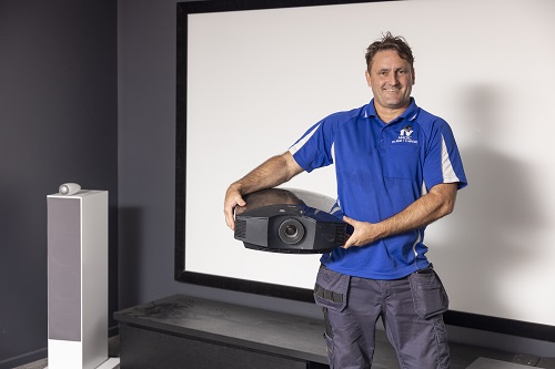 technician holding a projector ready to replace the lamp