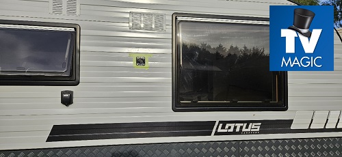 Close up of the side of a caravan. TV Magic logo in top right corner