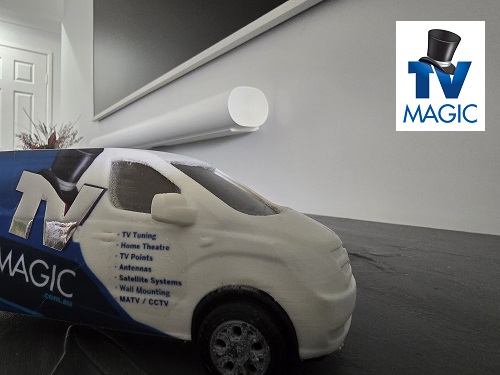 Close up of a mini TV Magic van beneath a floating soundbar and wall mounted TV