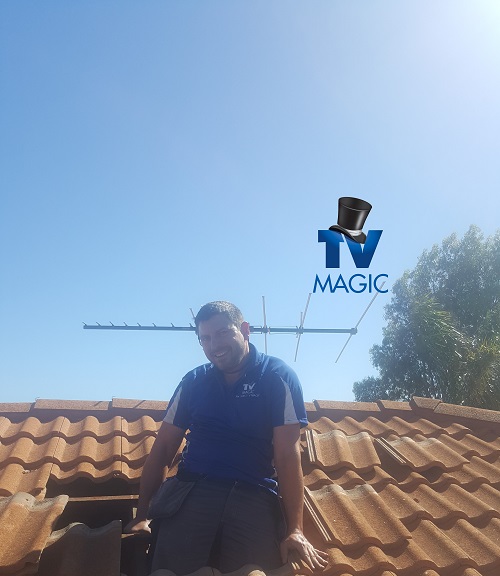 Technician on roof with with an antenna he just finished repairing