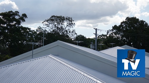 Various antennas on tin roofs by TV Magic. TV Magic logo in bottom right corner